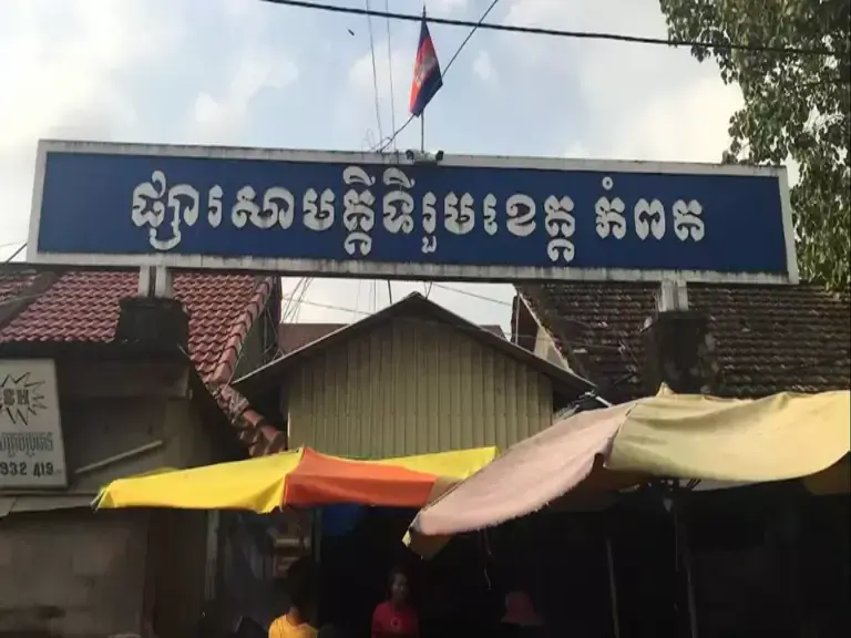 Kampot market entrance with Khmer sign and sun umbrellas